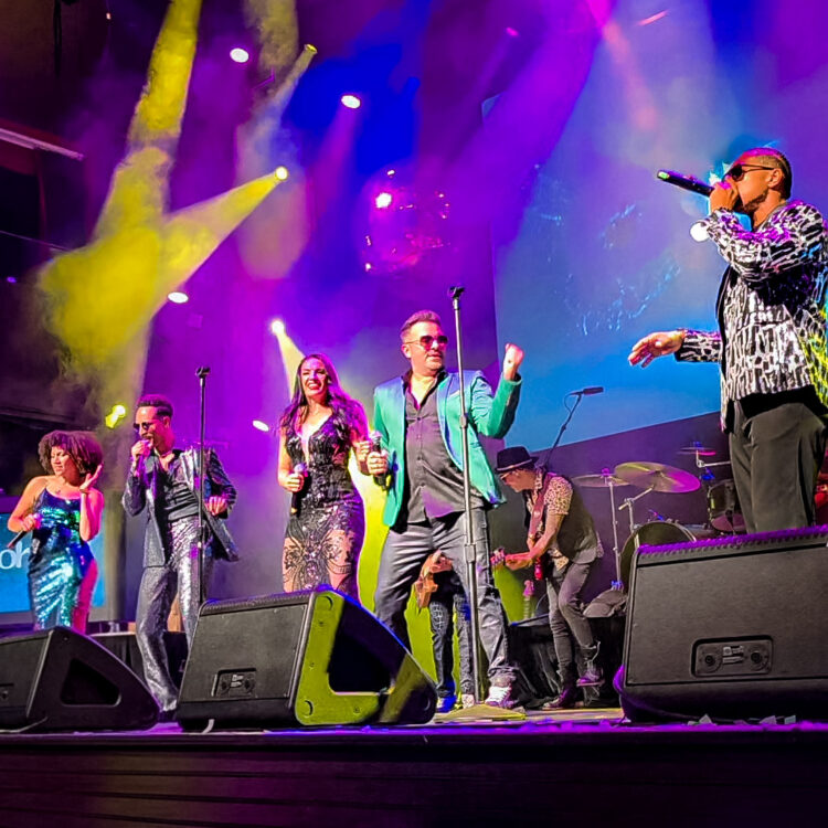 Million Dollar Band performing live in Las Vegas — four vocalists and a vocal percussionist delivering high-energy corporate entertainment.